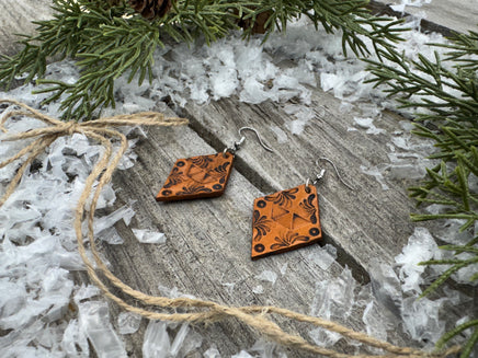 Diamond-shaped hand-stamped leather earrings with scroll design, light brown with sterling silver hooks, handmade by Cherokee Rose Custom Leather in East Texas.