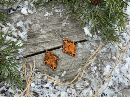 Diamond-shaped hand-stamped leather earrings with scroll design, light brown with sterling silver hooks, handmade by Cherokee Rose Custom Leather in East Texas.