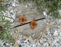 Small diamond-shaped hand-stamped leather earrings with Southwestern sun design and sterling silver hooks, handmade by Cherokee Rose Custom Leather in Texas