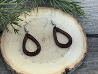 Small hand-stamped leather teardrop earrings with floral and rope design, chocolate brown with sterling silver hooks, handmade by Cherokee Rose Custom Leather in Texas.