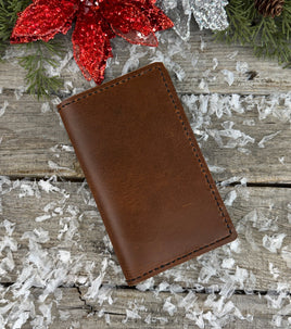 Handmade leather Field Notes cover in smooth oil-tanned brown leather with black stitching, crafted by Cherokee Rose Custom Leather in East Texas.