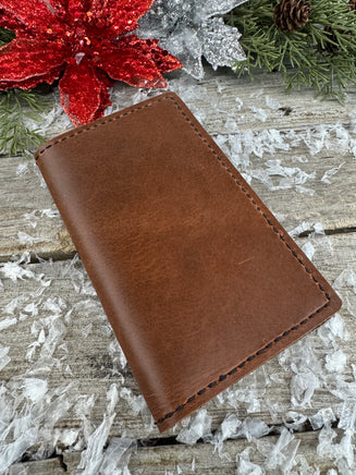 Handmade leather Field Notes cover in smooth oil-tanned brown leather with black stitching, crafted by Cherokee Rose Custom Leather in East Texas.