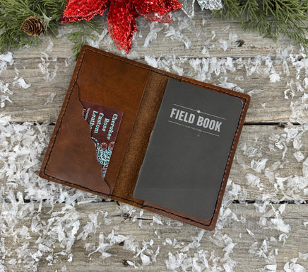 Handmade leather Field Notes cover in smooth oil-tanned brown leather with black stitching, crafted by Cherokee Rose Custom Leather in East Texas.