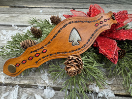 Hand-tooled leather cuff bracelet with arrowhead centerpiece, red diamond accents, and antique brass snaps, handmade by Cherokee Rose Custom Leather in Texas.