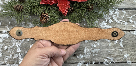 Hand-tooled leather cuff bracelet with arrowhead centerpiece, red diamond accents, and antique brass snaps, handmade by Cherokee Rose Custom Leather in Texas.