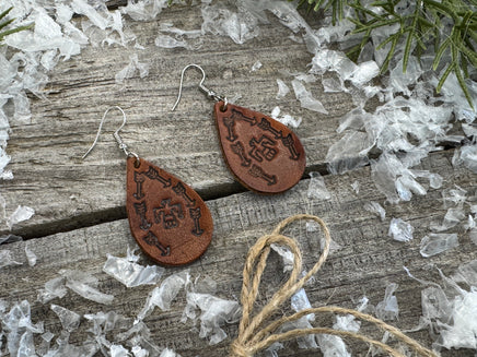 Medium brown teardrop leather earrings with Thunderbird and arrow stamped design, sterling silver ear wires, handmade by Cherokee Rose Custom Leather in East Texas.