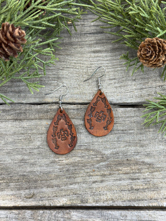 Medium brown teardrop leather earrings with Thunderbird and arrow stamped design, sterling silver ear wires, handmade by Cherokee Rose Custom Leather in East Texas.