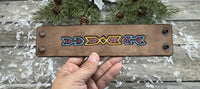 Wide hand-carved leather cuff bracelet with turquoise arrow and yellow tribal design, antique copper snaps, and yellow suede lining, handmade by Cherokee Rose Custom Leather.