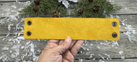 Wide hand-carved leather cuff bracelet with turquoise arrow and yellow tribal design, antique copper snaps, and yellow suede lining, handmade by Cherokee Rose Custom Leather.