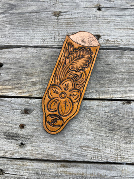 Decorative leather tool with floral patterns on a wooden surface