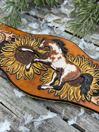 Wide hand-painted leather cuff bracelet with wild paint pony, sunflowers, and antique brass snaps, handmade by Cherokee Rose Custom Leather in East Texas.